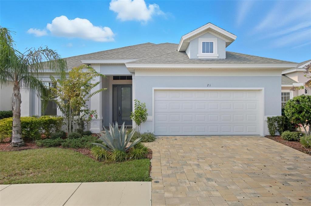 A single-story house with a light blue exterior, a two-car garage, and a paved driveway — 21 SPRING STREET, PALM COAST, FL