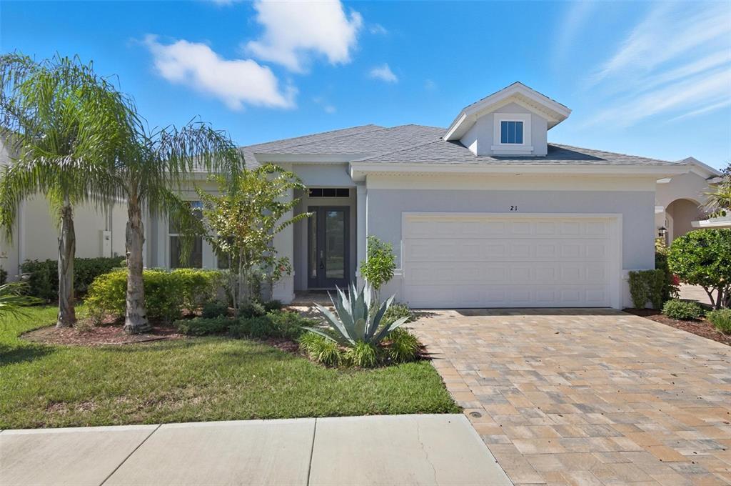A single-story house with a gray exterior, a two-car garage, and a paved driveway — 21 SPRING STREET, PALM COAST, FL