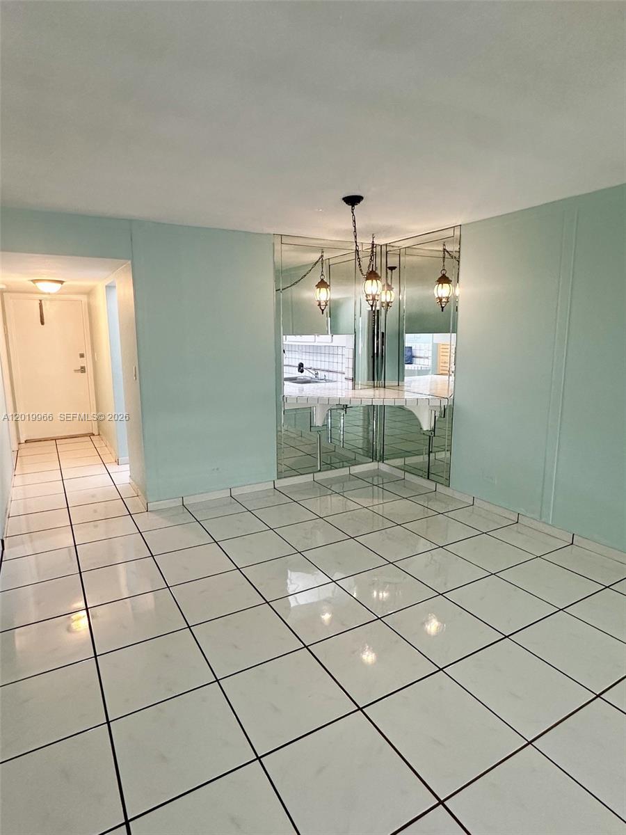 A dining area features white tiled floors, mirrored walls, and a hanging light fixture — 300 Galen Dr # 206, Key Biscayne FL 33149, KEY BISCAYNE, FL
