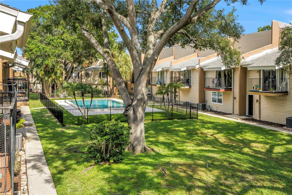 An outdoor view of a swimming pool surrounded by a black fence and apartment buildings — 5403 SWEETWATER TERRACE CIRCLE UNIT 5403, TAMPA, FL