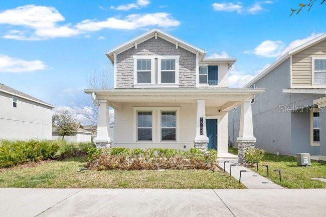 A two-story suburban house with a front porch, gray siding, and a concrete driveway — 16153 WATER SPRING BOULEVARD, WINTER GARDEN, FL