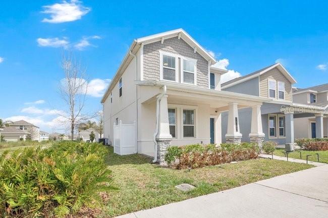 A two-story suburban house with a covered front porch and light-colored siding — 16153 WATER SPRING BOULEVARD, WINTER GARDEN, FL