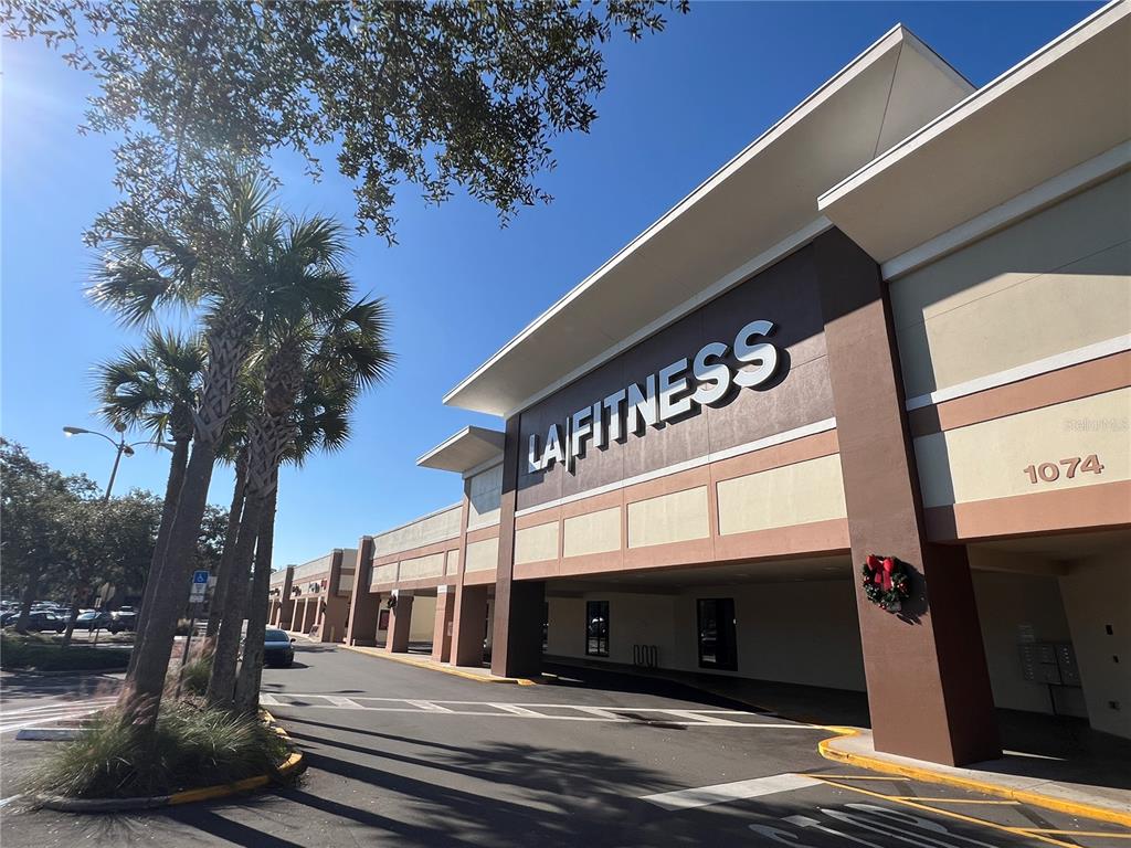 The exterior of a commercial building features an LA Fitness sign and palm trees — 1074 MONTGOMERY ROAD UNIT 1042-1046, ALTAMONTE SPRINGS, FL
