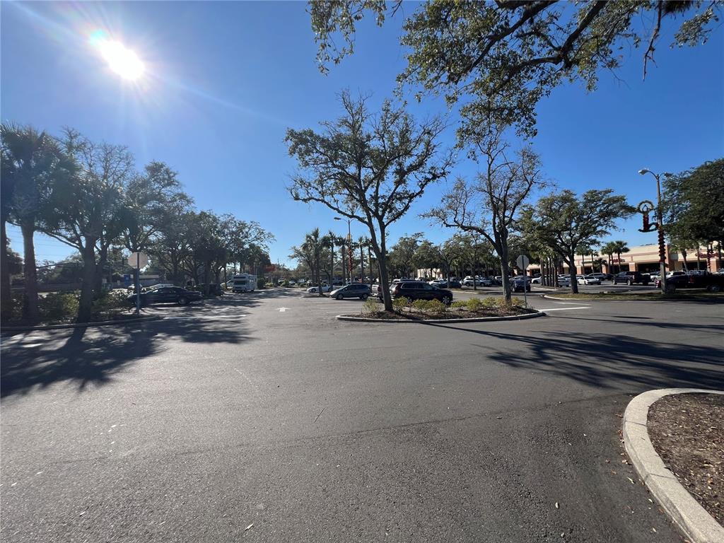 A sunny outdoor parking lot with trees and a view of a shopping center — 1074 MONTGOMERY ROAD UNIT 1042-1046, ALTAMONTE SPRINGS, FL