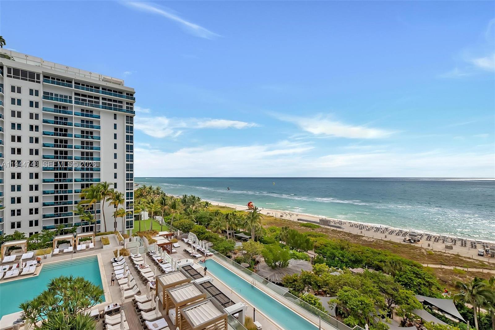 An elevated view shows a high-rise building overlooking a swimming pool, beach, and ocean — 2301 Collins Ave # 810, Miami Beach FL 33139, MIAMI BEACH, FL