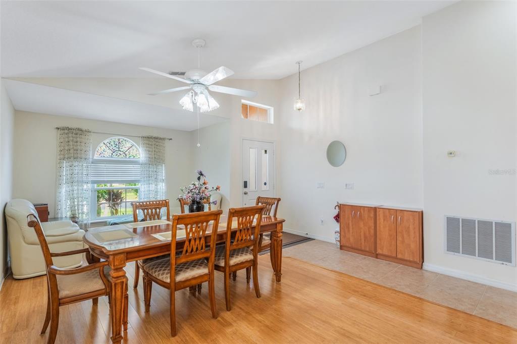 A dining room with wood flooring, a wooden table with chairs, and a ceiling fan — 5389 WATERVISTA DRIVE, ORLANDO, FL