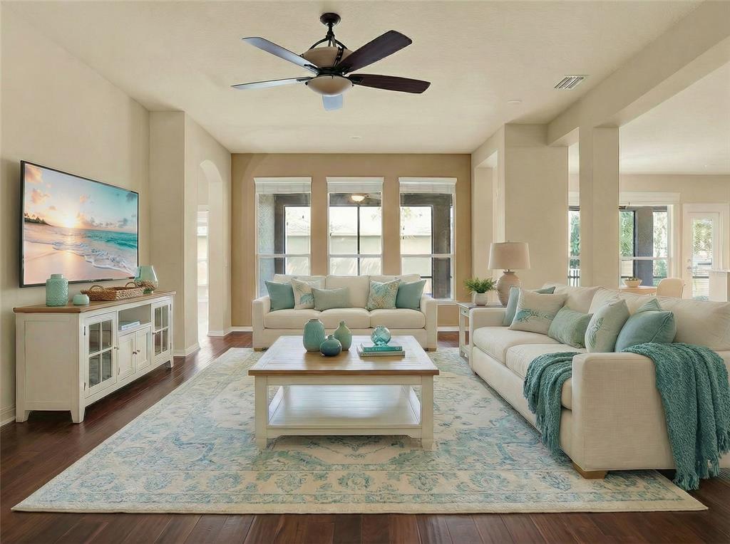 A living room features white sofas, a wooden coffee table, and a large area rug — 7018 CARDINALWOOD LANE, LAND O LAKES, FL