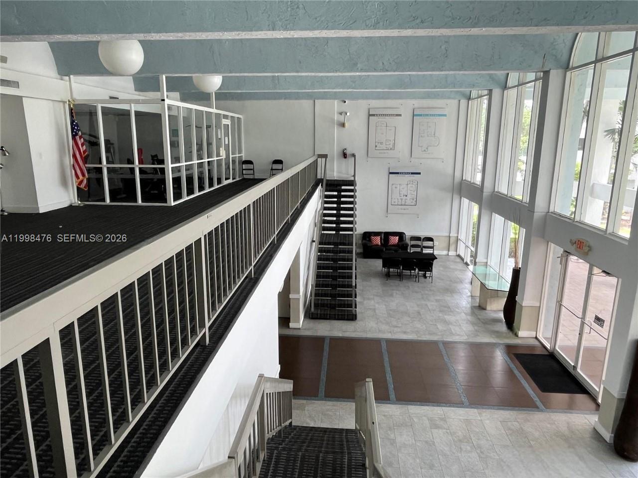 A multi-level lobby features a carpeted mezzanine, a central staircase, and floor-to-ceiling windows — 494 NW 165th St Rd # 601, Miami FL 33169, MIAMI, FL