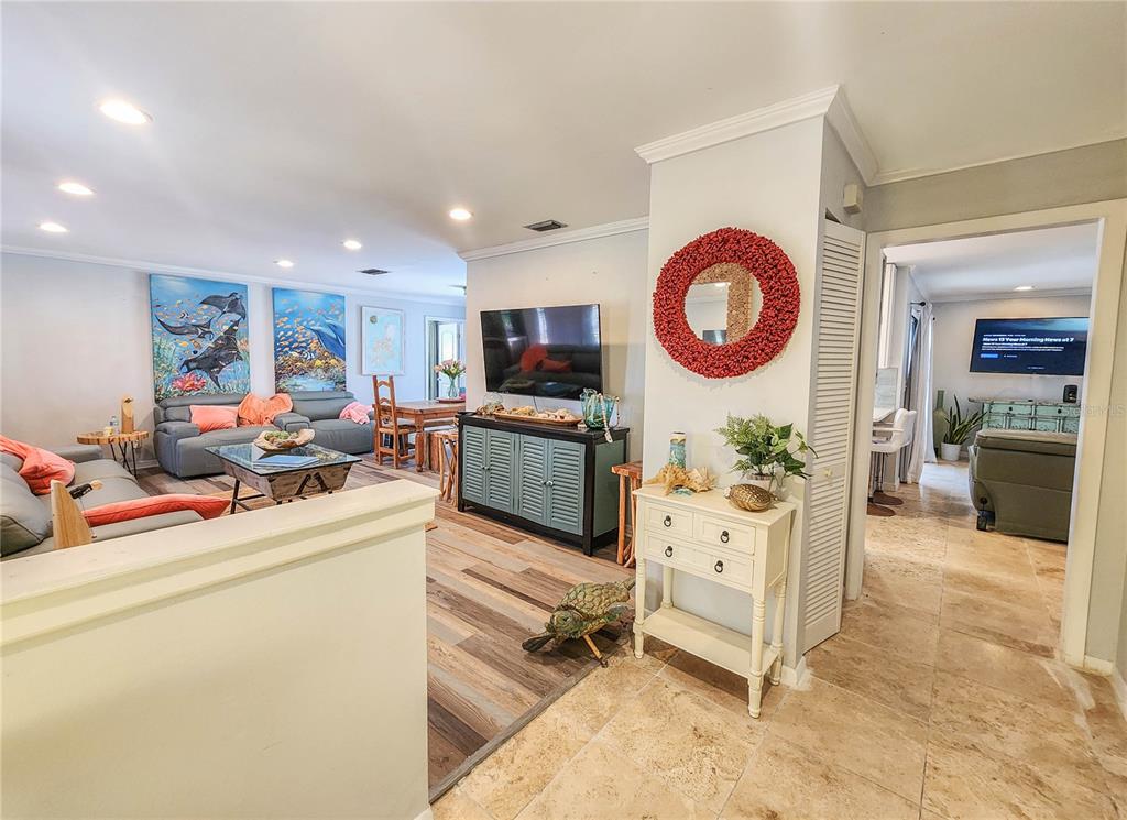 A living room features a grey sofa, a television on a console, and tiled flooring — 24 CLARIDGE COURT S, PALM COAST, FL