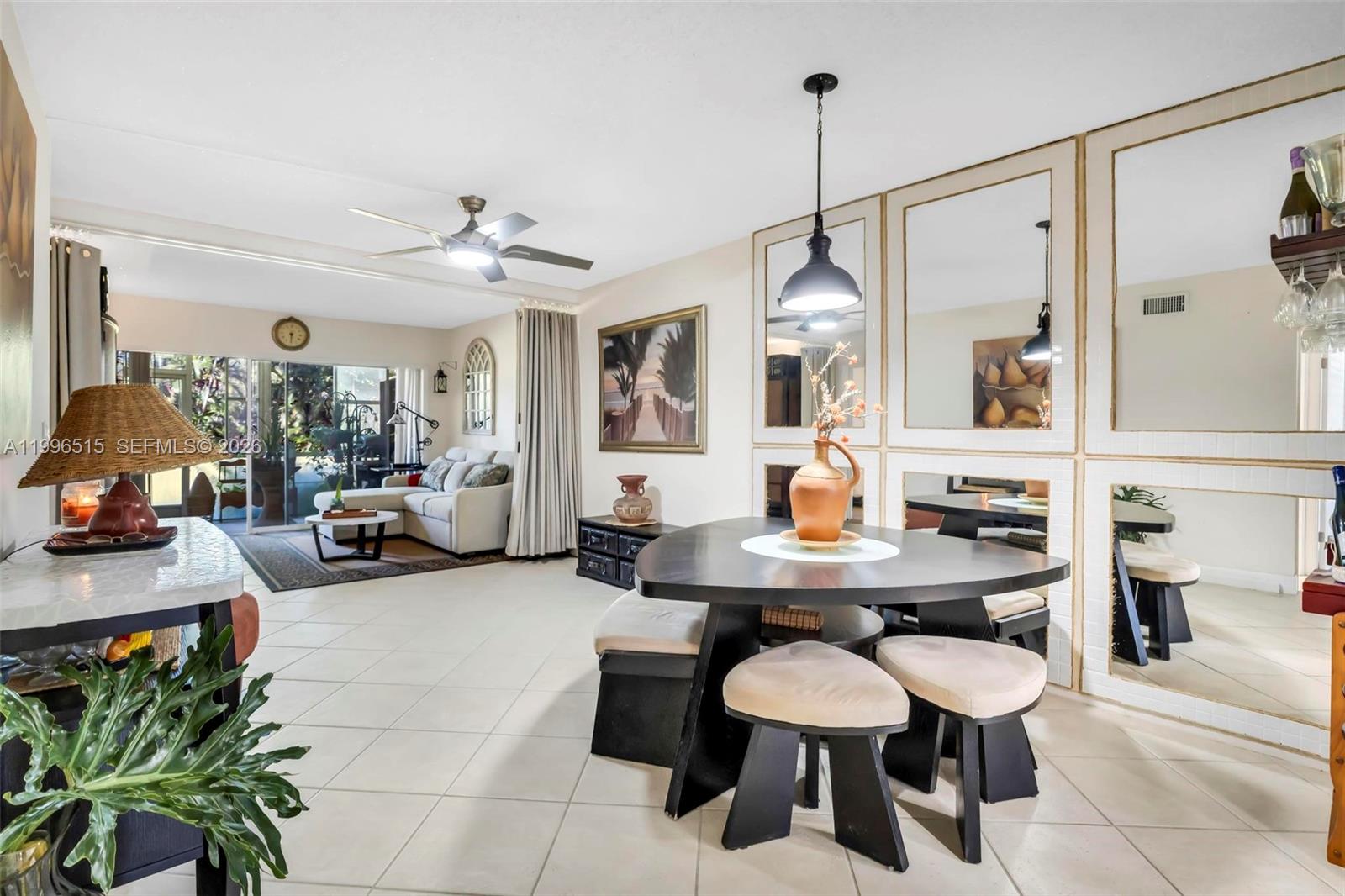 A dining area with a triangular table sits adjacent to a living room with tile floors — 2300 SW 22nd Ave # 109, Delray Beach FL 33445, DELRAY BEACH, FL