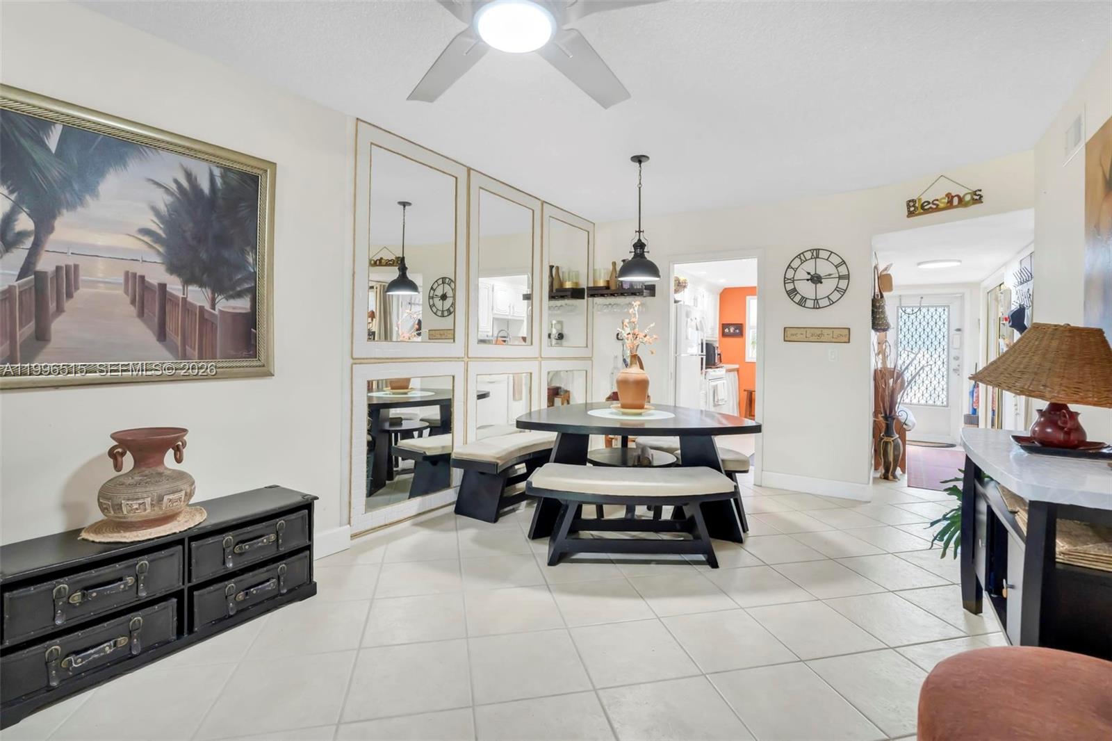 A dining area features a round table with benches, mirrored wall panels, and tile flooring — 2300 SW 22nd Ave # 109, Delray Beach FL 33445, DELRAY BEACH, FL
