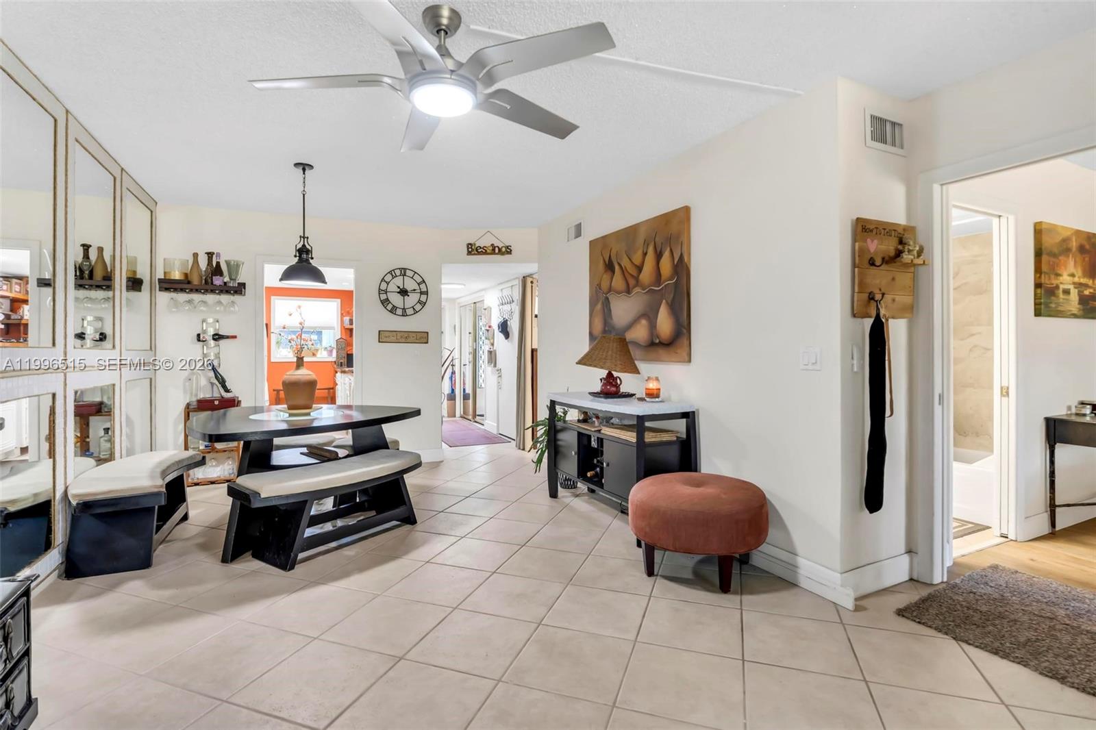 A dining area features a table with benches, tiled floors, and a ceiling fan — 2300 SW 22nd Ave # 109, Delray Beach FL 33445, DELRAY BEACH, FL