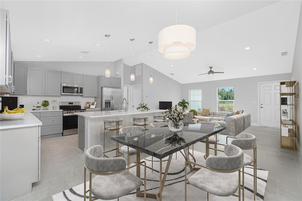 An open-concept kitchen and dining area features gray cabinetry, a marble-topped island, and tile flooring — 5208 CITRON ROAD, NORTH PORT, FL