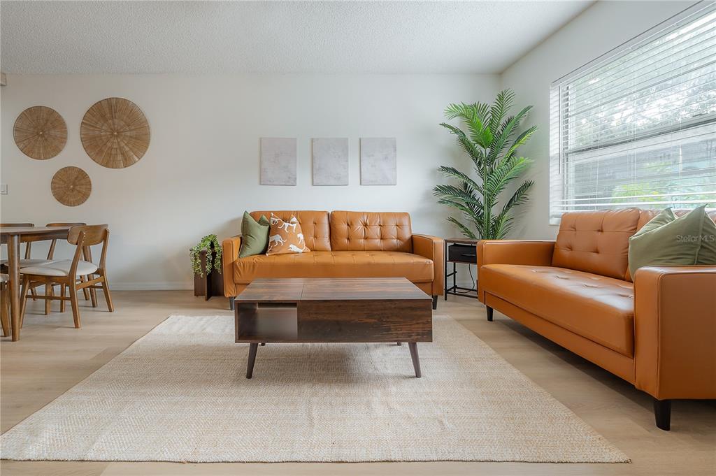 A living room features two tan leather sofas, a wooden coffee table, and a dining set — 6908 S MACDILL AVENUE UNIT A, TAMPA, FL
