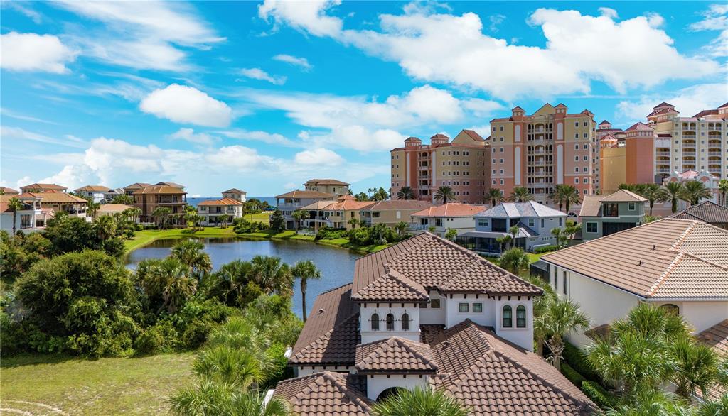 An aerial view shows a residential neighborhood with houses, a pond, and large resort buildings — 21 NORTHSHORE DRIVE, PALM COAST, FL