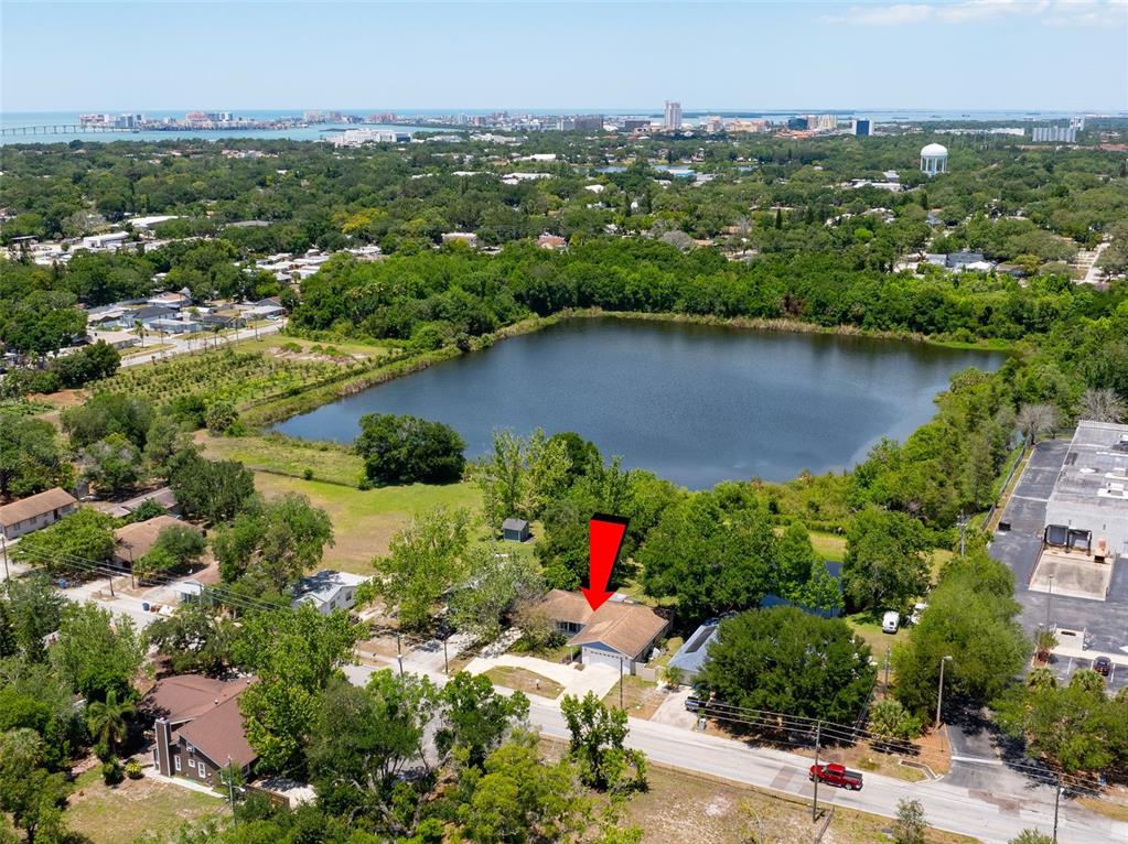 An aerial view shows a single-story house with a red arrow pointing to its roof — 1130 WYATT STREET, CLEARWATER, FL