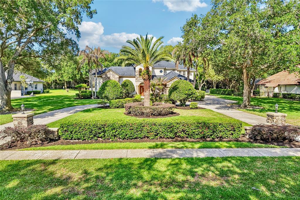 An aerial view shows a large house with a dark roof surrounded by lush trees — 2068 ROBERTS POINT DRIVE, WINDERMERE, FL