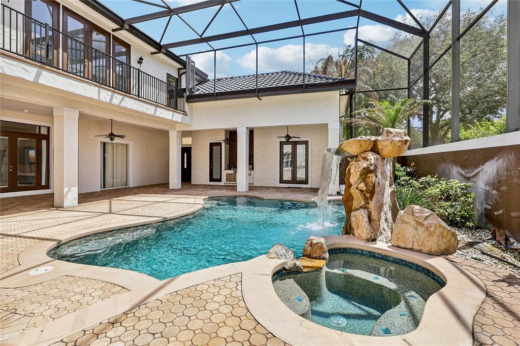 A stone-accented house exterior features a double wooden front door and a paved walkway — 2068 ROBERTS POINT DRIVE, WINDERMERE, FL