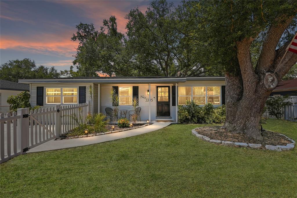 A single-story house with a white exterior, a front porch, and a large oak tree — 3305 W BALLAST POINT BOULEVARD, TAMPA, FL