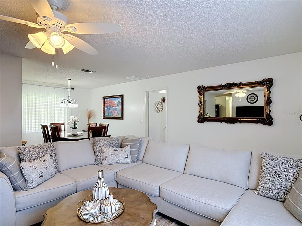 A living room features a large sectional sofa, a coffee table, and a wall mirror — 1535 LAVILLA STREET, DELTONA, FL