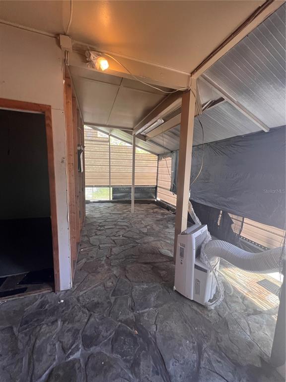 A covered patio with a stone floor, a portable air conditioner, and a screened enclosure — 3029 FORSYTH ROAD, WINTER PARK, FL