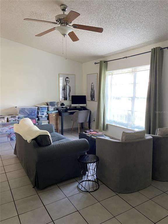 A living room features a sofa, two armchairs, a desk, and a ceiling fan — 3133 QUAIL DR, DELTONA, FL