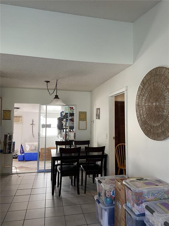 A dining area with a table and chairs leads to a sunroom through sliding doors — 3133 QUAIL DR, DELTONA, FL