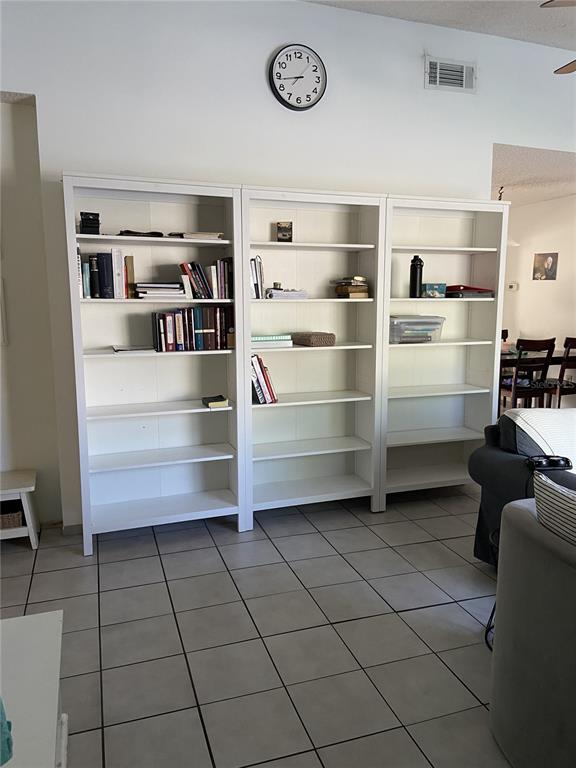 Three white bookshelves stand against a white wall above a tiled floor — 3133 QUAIL DR, DELTONA, FL