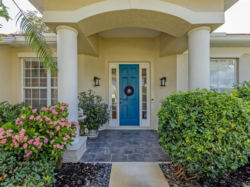 A front entryway features a blue door, two white columns, and a tiled porch — 905 BRAMLEY COURT UNIT 9, VENICE, FL