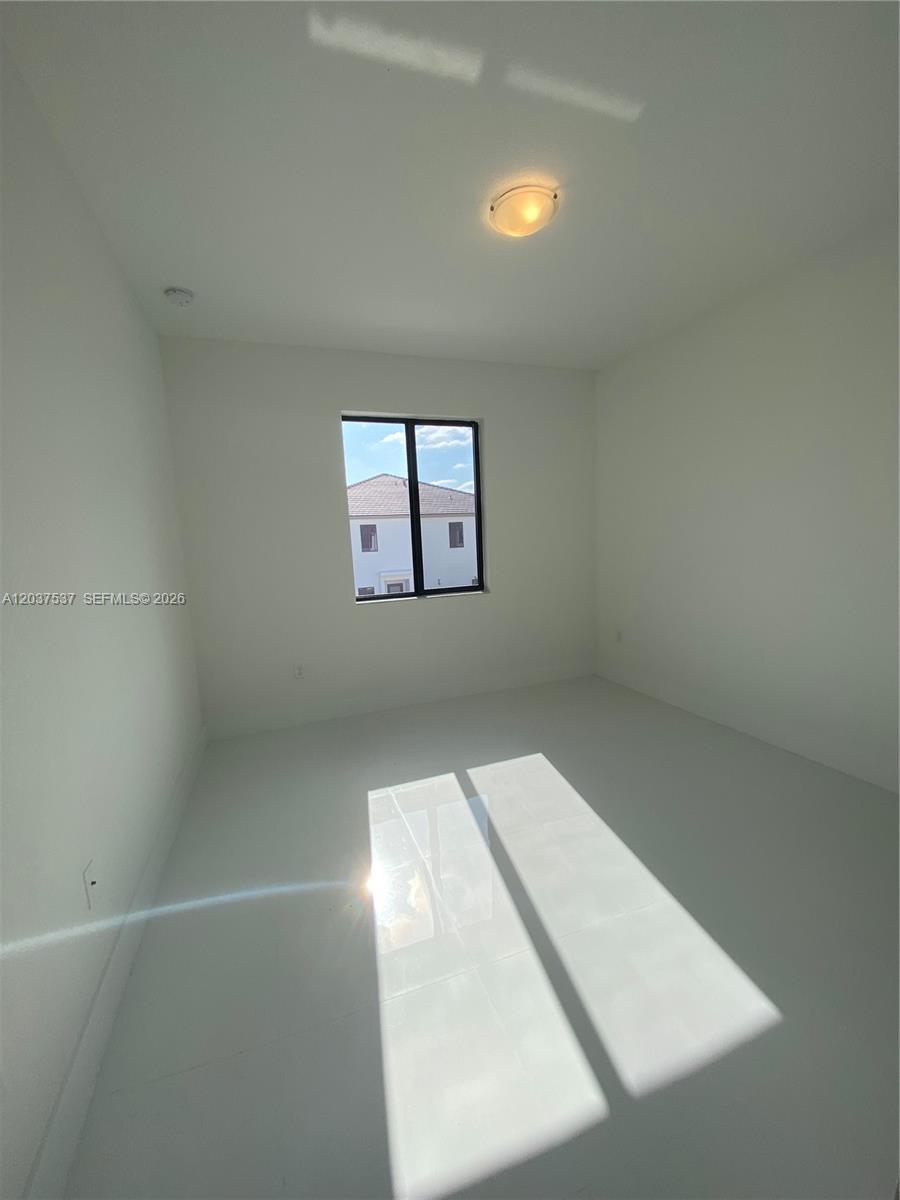 An empty bedroom features white walls, a single window, and a flush-mount ceiling light — 2402 SW 145th Pl # 0, Miami FL 33175, MIAMI, FL