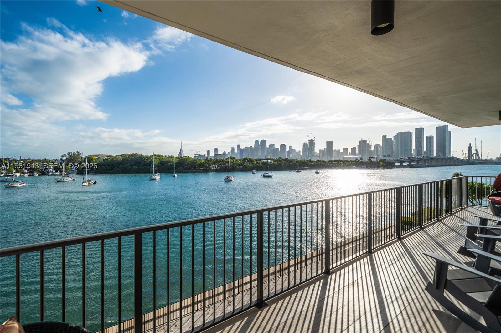 A balcony with a metal railing overlooks a bay with boats and a city skyline — 1000 Venetian Way # 403, Miami Beach FL 33139, MIAMI BEACH, FL
