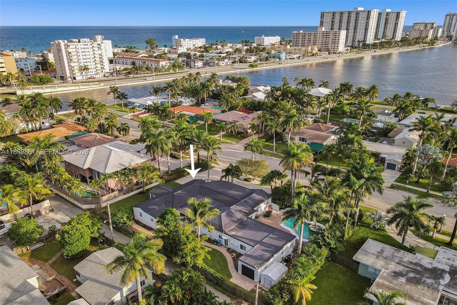 An aerial view shows a single-story house with a dark roof, pool, and palm trees — 725 Harrison St, Hollywood FL 33019, HOLLYWOOD, FL