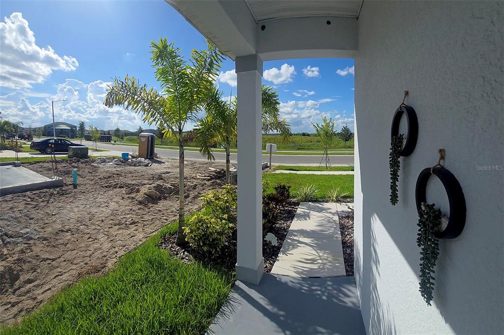 A view from a covered porch looking out toward a street and construction site — 5539 MADDIE DRIVE, HAINES CITY, FL