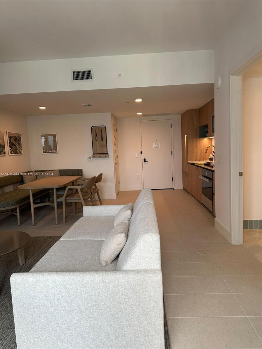 This open-concept living area features a sofa, dining nook, and a modern galley kitchen — 159 NE 6 th Street # 3513, Miami FL 33132, MIAMI, FL