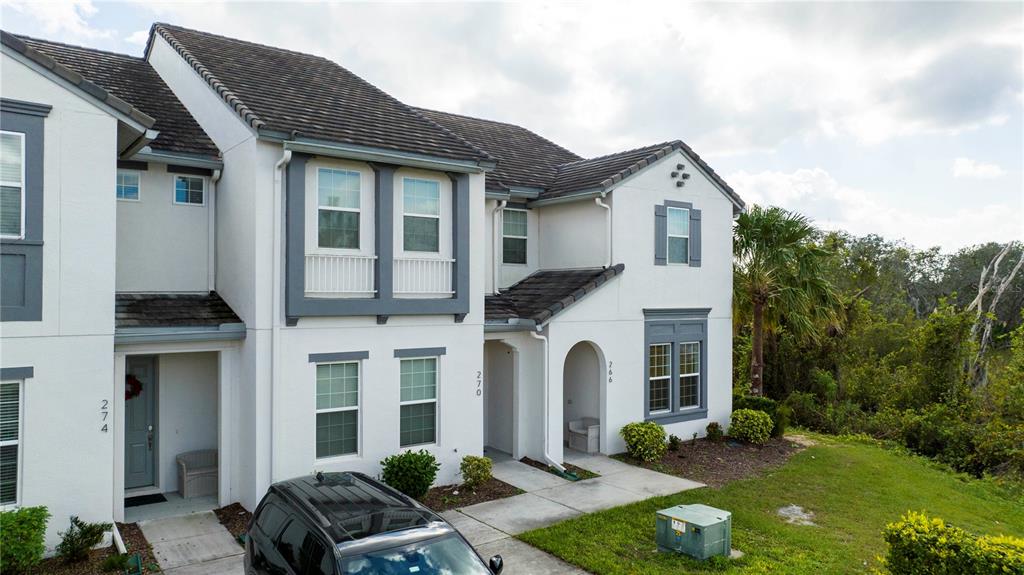 An exterior view of a multi-unit townhouse building with white stucco walls and dark trim — 270 CAPTIVA DRIVE, DAVENPORT, FL