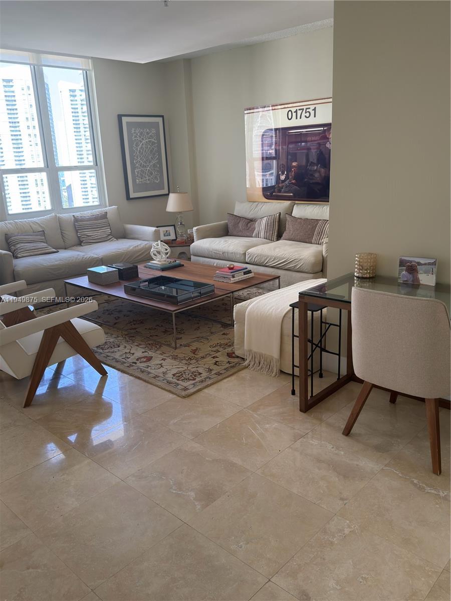 A living room features two sofas, a coffee table, a rug, and a glass desk — 701 Brickell Key Blvd # 08, Miami FL 33131, MIAMI, FL