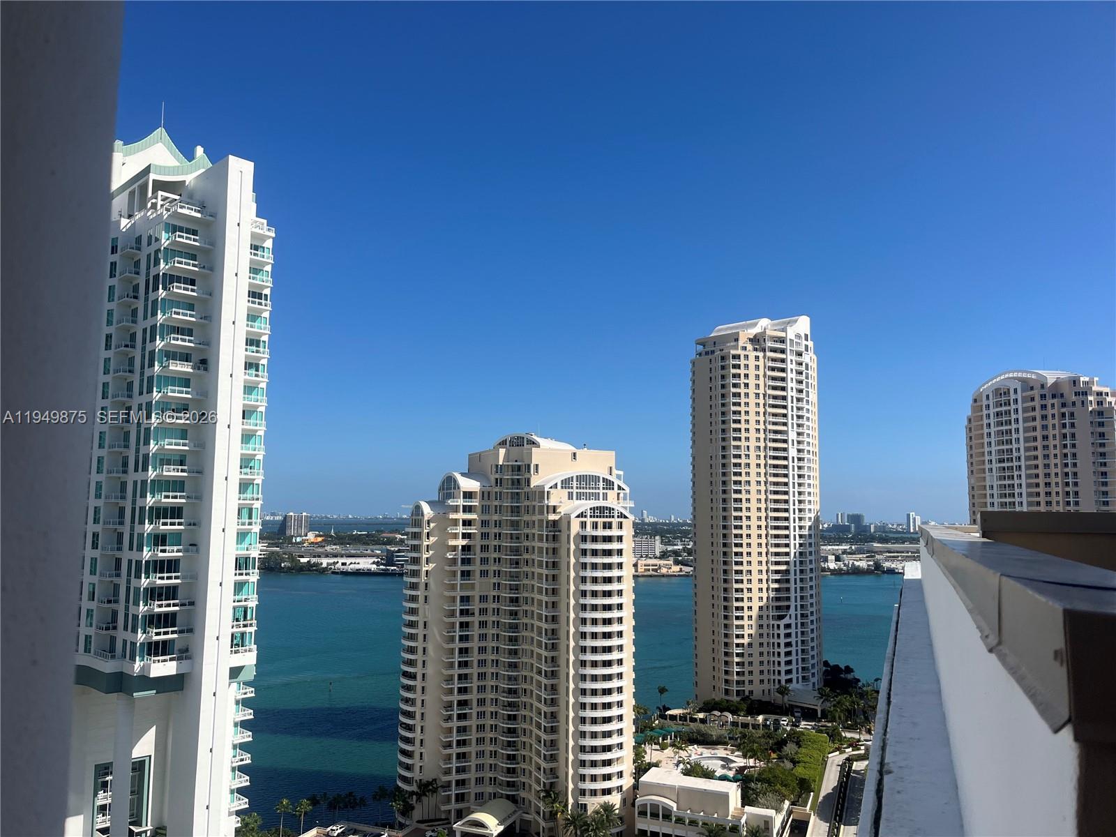 A high-angle view shows several tall residential towers overlooking a bay under a clear sky — 701 Brickell Key Blvd # 08, Miami FL 33131, MIAMI, FL