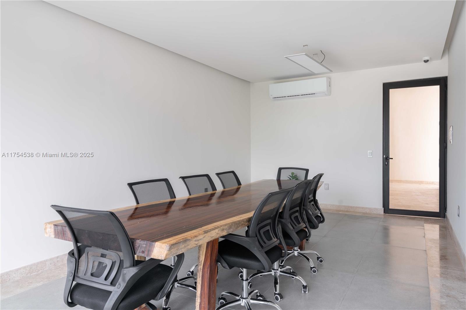 A conference room features a live-edge wooden table, black mesh chairs, and tile flooring — 1 Ave del Parque # 25, TX 77760, TX