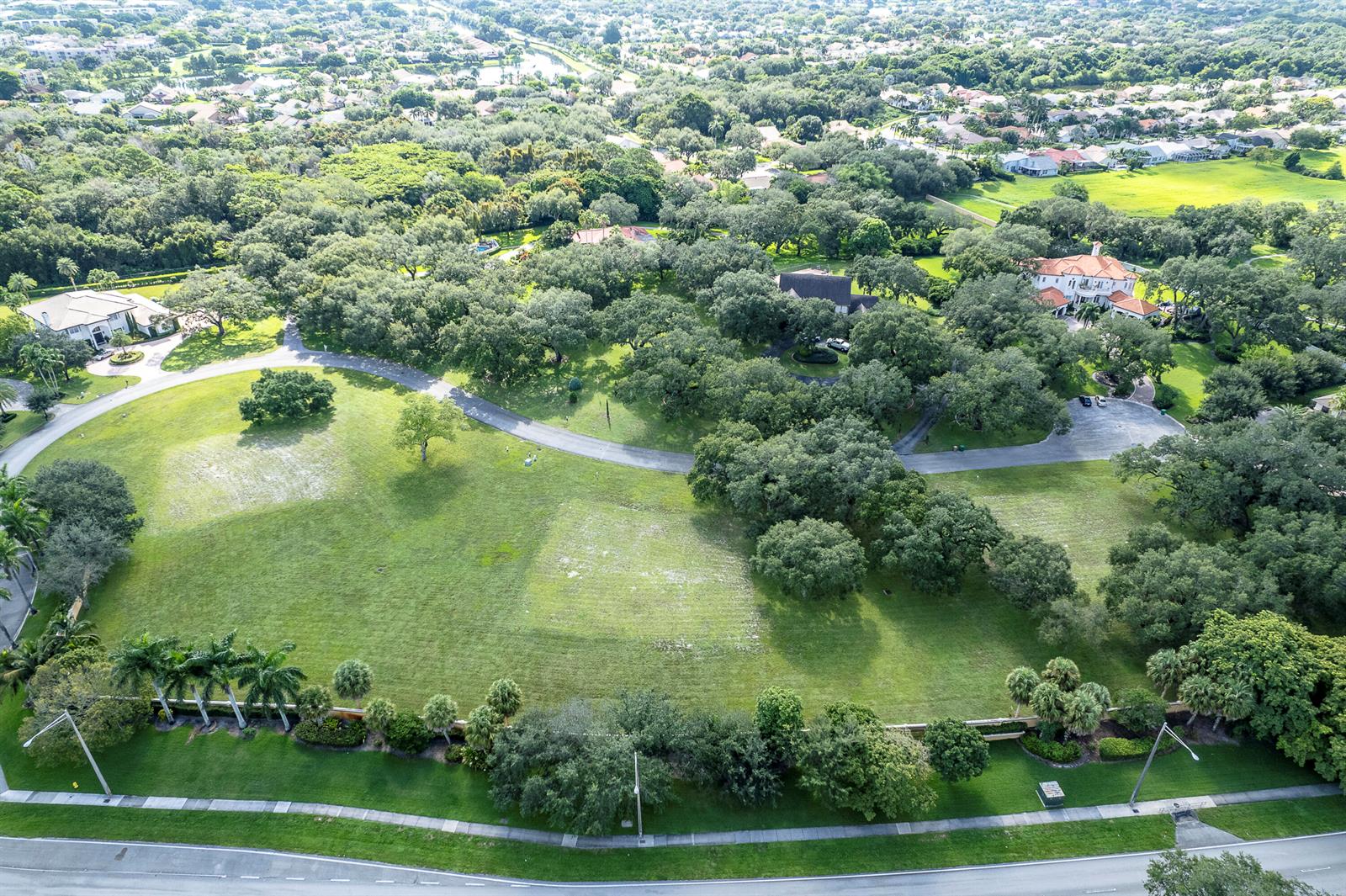 An aerial view shows a large, grassy residential lot surrounded by mature trees and homes — 9900 Winding Rdg Lane, Davie FL 33324, DAVIE, FL