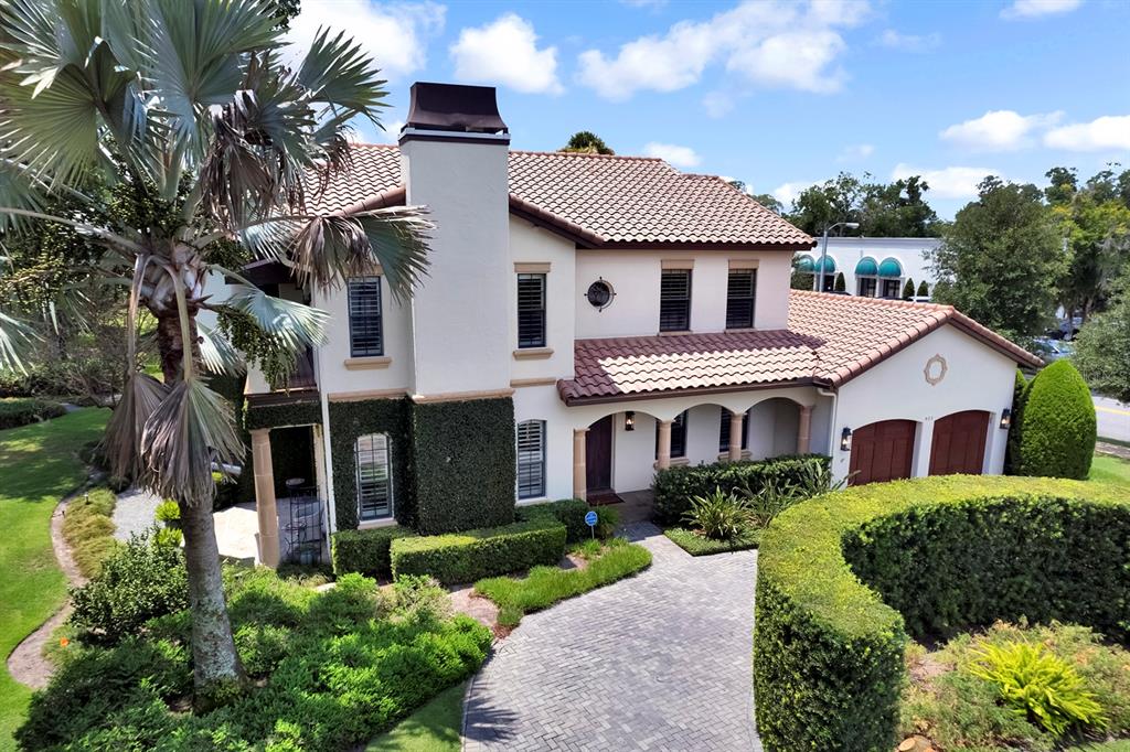 An exterior view of a two-story stucco house with a tiled roof and paved driveway — 922 N PENNSYLVANIA AVENUE, WINTER PARK, FL