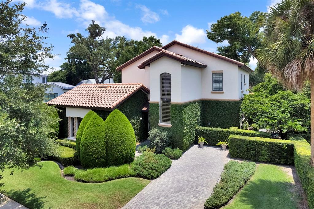 A two-story stucco house with a tiled roof and ivy-covered walls features a paved driveway — 922 N PENNSYLVANIA AVENUE, WINTER PARK, FL