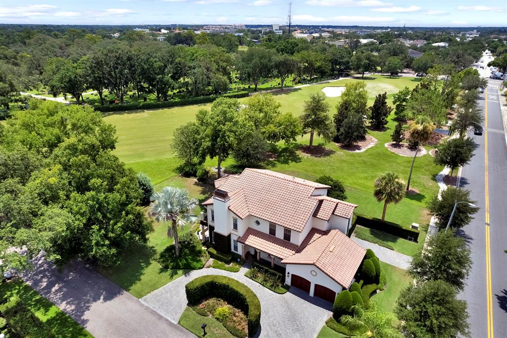An aerial view shows a two-story house with a tiled roof next to a golf course — 922 N PENNSYLVANIA AVENUE, WINTER PARK, FL