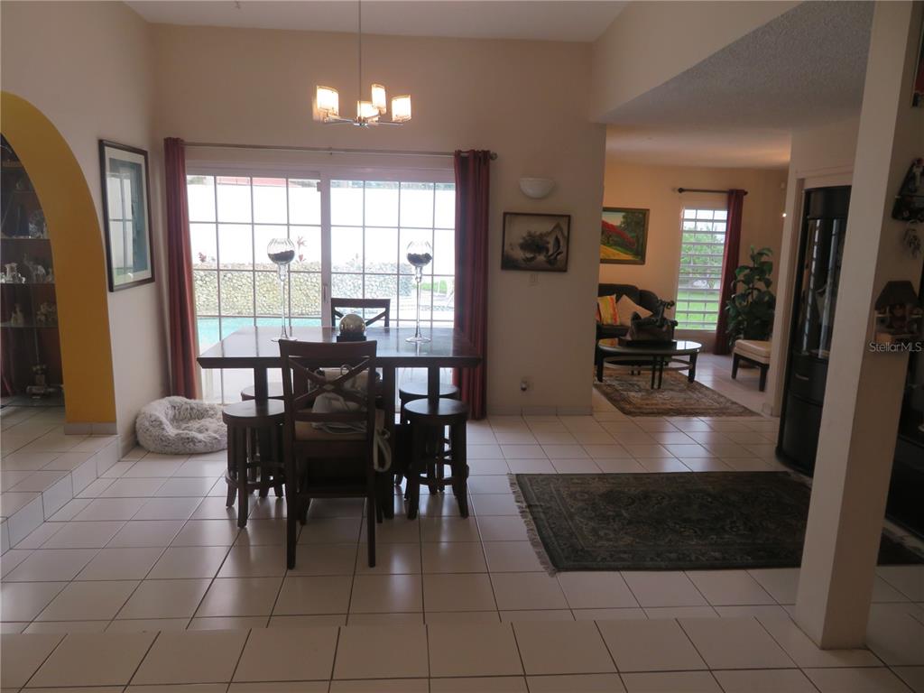 A dining area with tile floors, a wooden table, and a sliding glass door view — Dorado del Mar PELICANO, DORADO, PR