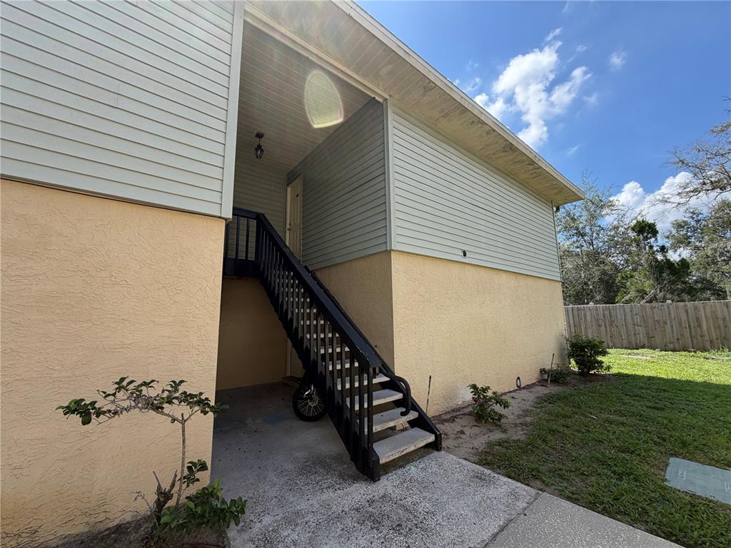 An exterior view shows a two-story building with a black staircase leading to an entrance — 510 GOLDEN RAINTREE PLACE, BRANDON, FL