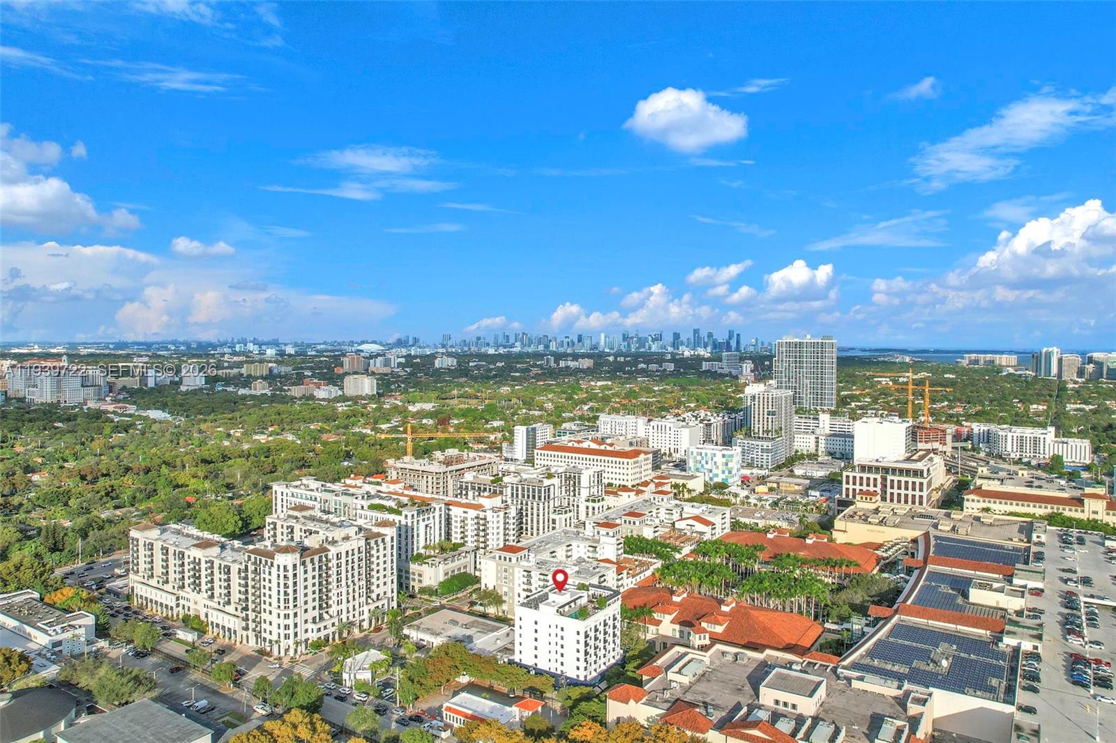 An aerial view shows a dense urban neighborhood with mid-rise buildings and a distant city skyline — 4220 Laguna St # 505, Coral Gables FL 33146, CORAL GABLES, FL