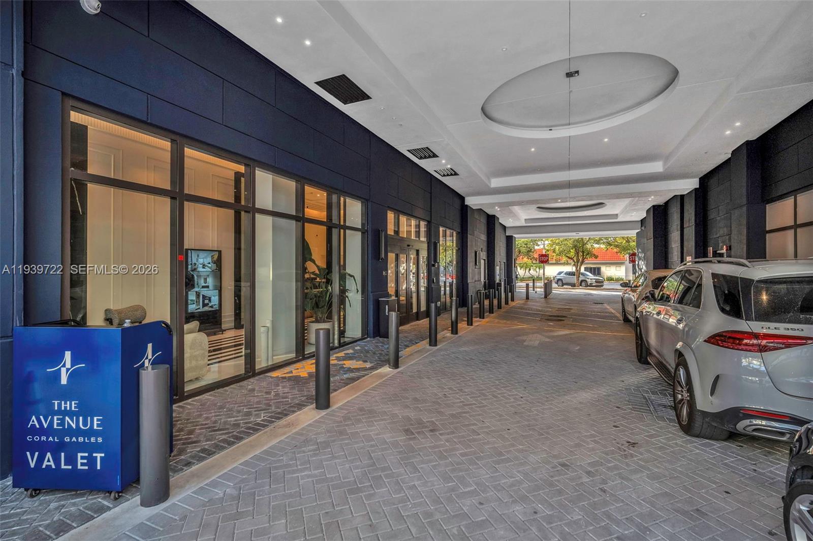 A valet drop-off area features a paved driveway, dark exterior walls, and glass storefront windows — 4220 Laguna St # 505, Coral Gables FL 33146, CORAL GABLES, FL