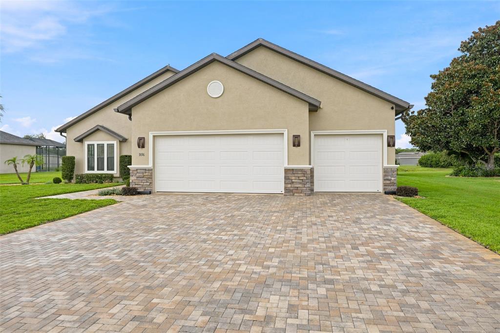 A single-story house with a beige stucco exterior, stone accents, and a paved driveway — 9196 PALM BEACH DRIVE, BROOKSVILLE, FL