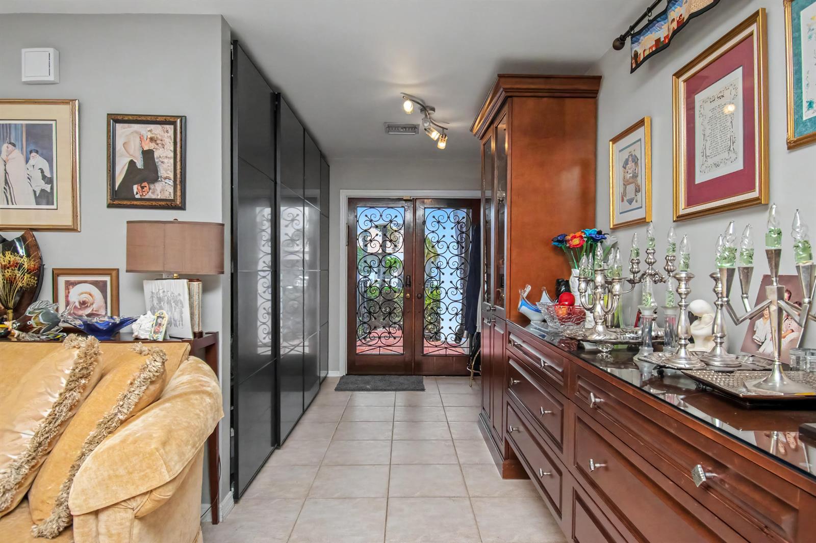 A foyer features tile flooring, a dark wood cabinet, and double doors with decorative metal grilles — 7678 Solimar Circle, Boca Raton FL 33433, BOCA RATON, FL