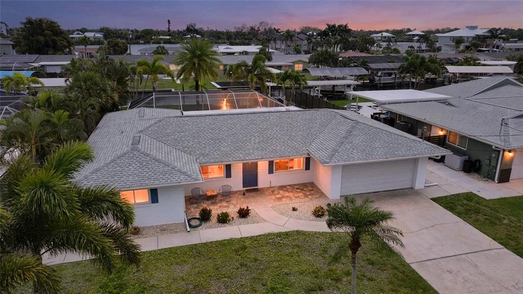 An aerial view of a single-story house with a gray roof and a screened pool — 1433 LEMON BAY DRIVE, ENGLEWOOD, FL