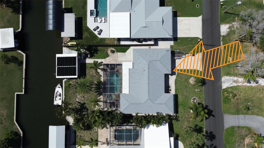 An aerial view shows a residential house with a pool, boat dock, and driveway — 1433 LEMON BAY DRIVE, ENGLEWOOD, FL